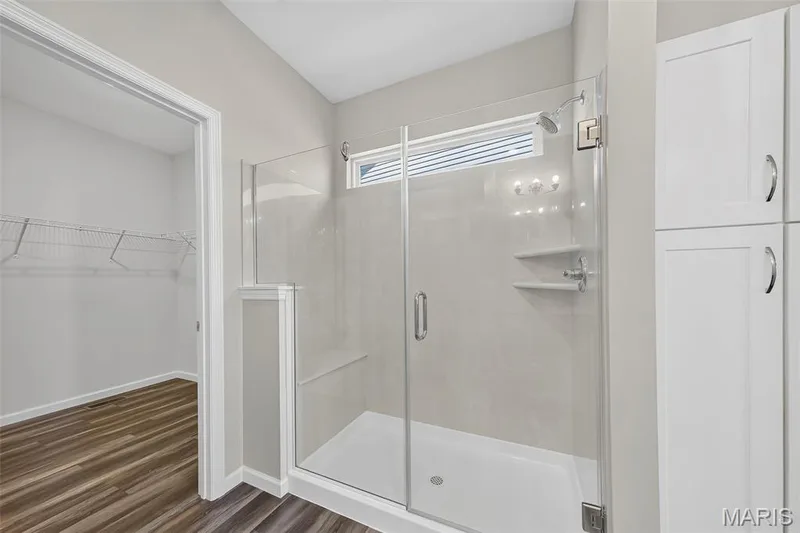 Glass-enclosed shower with a built-in bench, tiled walls, and integrated shelving — 622 Cruden Bay Court, Dardenne Prairie, MO 63368