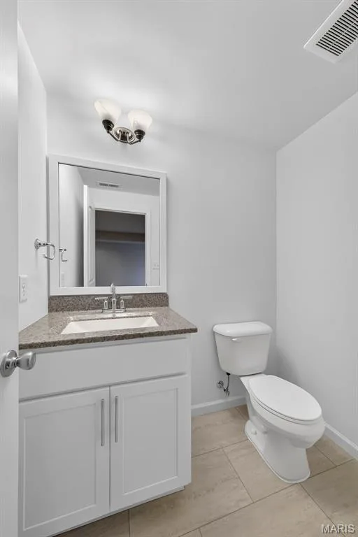 White vanity with shaker-style cabinetry, granite countertop, undermount sink, and polished chrome faucet — 622 Cruden Bay Court, Dardenne Prairie, MO 63368