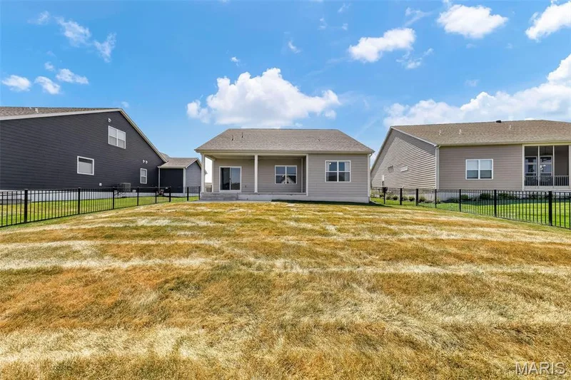 Rear exterior featuring a covered patio, sliding glass door, and multiple windows — 622 Cruden Bay Court, Dardenne Prairie, MO 63368