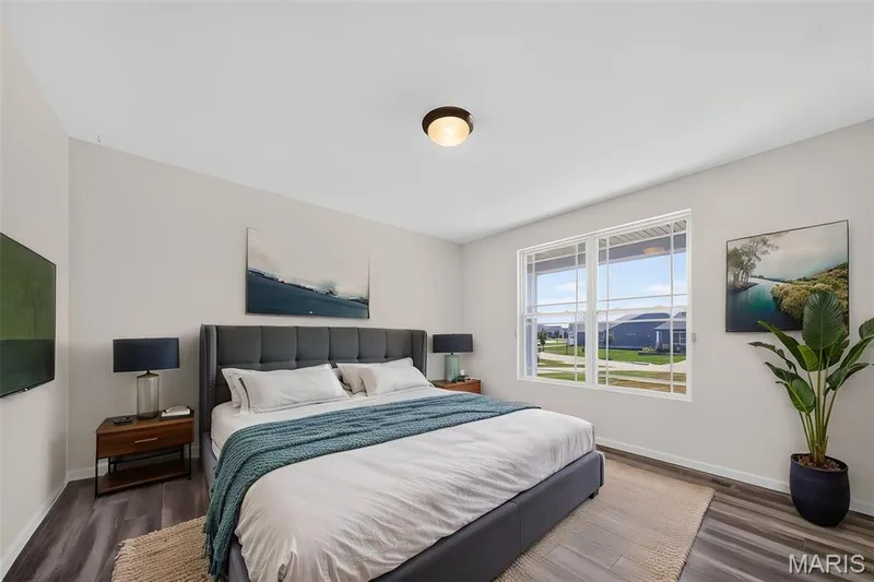 Spacious room featuring wood-finish flooring, a contemporary ceiling light fixture, and a large multi-pane window — 622 Cruden Bay Court, Dardenne Prairie, MO 63368