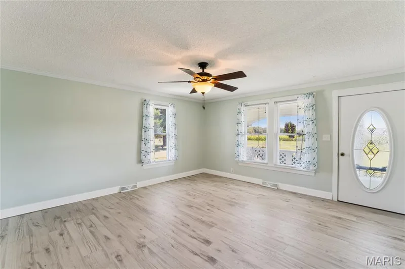 Wood-finish flooring throughout, complemented by a ceiling fan with integrated lighting — 435 Highway T, Foristell, MO 63348