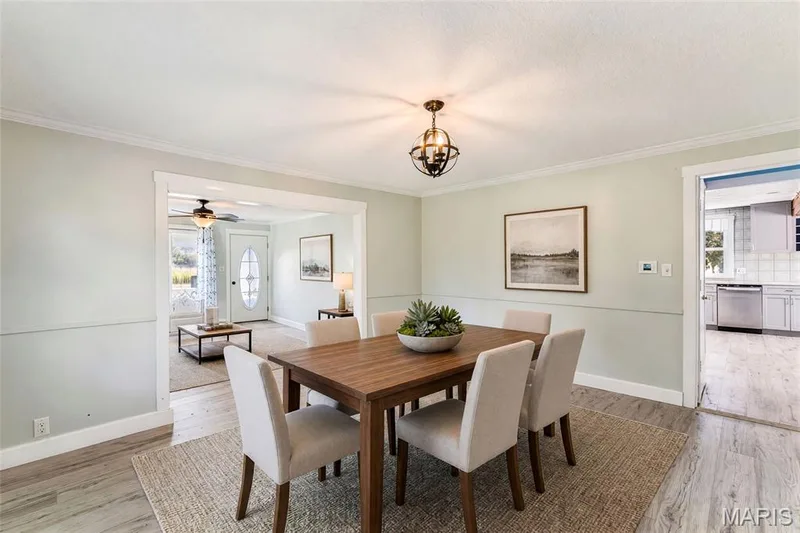 Dining area with crown molding, chair rail molding, and wood-finish flooring — 435 Highway T, Foristell, MO 63348