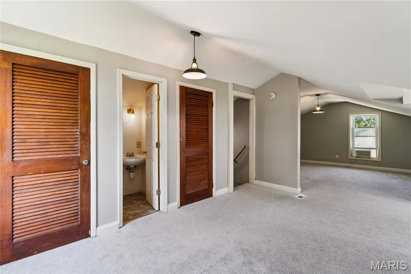 Light gray carpeting, multiple doorways, interior wall-mounted sink, exposed plumbing, and angled ceilings — 435 Highway T, Foristell, MO 63348