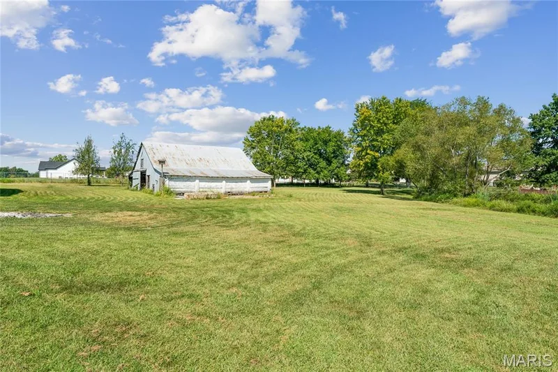 Expansive green space with an outbuilding featuring a metal roof and painted siding — 435 Highway T, Foristell, MO 63348