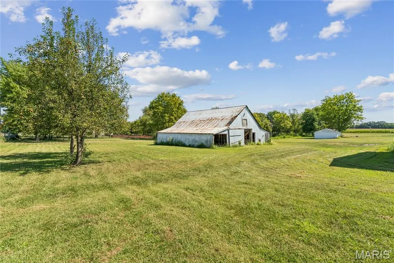 Expansive grassy area featuring a barn structure and mature trees — 435 Highway T, Foristell, MO 63348