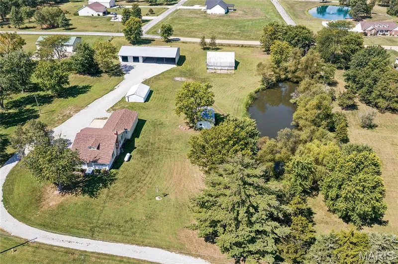 Single-story residence featuring a brown shingle roof and light-colored siding — 435 Highway T, Foristell, MO 63348