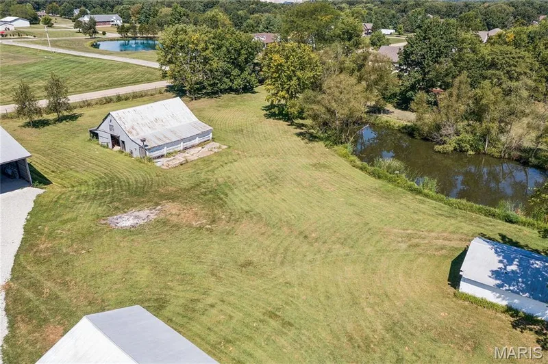 Expansive grassy grounds with two distinct outbuildings and a natural water feature — 435 Highway T, Foristell, MO 63348