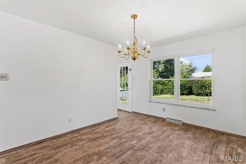 Separate dining room features tile wood-look tile flooring and chandelier — 109 Meadowlark Lane, St Charles, MO 63301