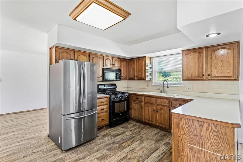 Kitchen features stainless french door refrigerator and gas range — 109 Meadowlark Lane, St Charles, MO 63301