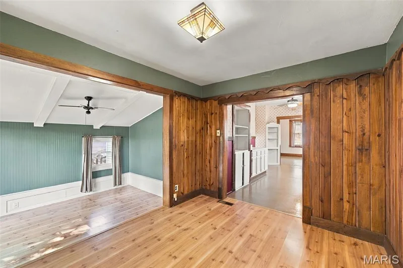 Back family Room features a cozy fireplace and steps down into a bright sunroom — 201 Perry Street, St Charles, MO 63301