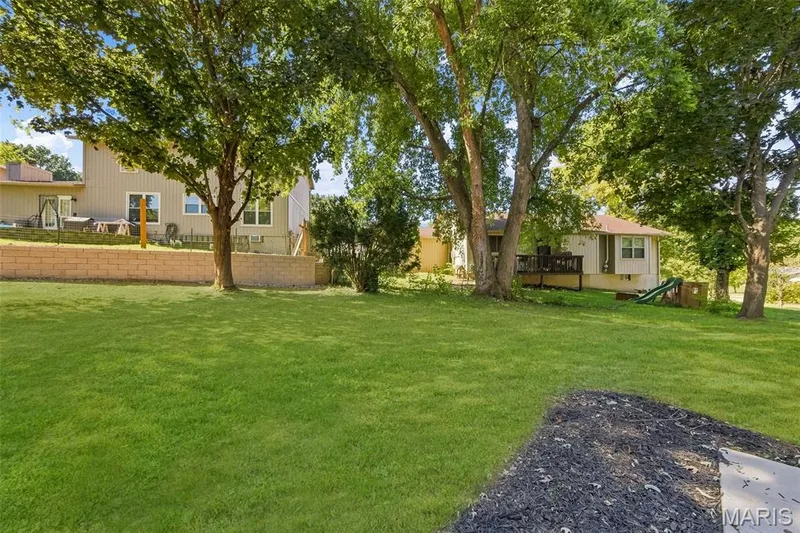 AI-enhanced image. Grass digitally restored to illustrate anticipated appearance following recent landscaping/retaining wall w — 18 Craigwood Drive, St Peters, MO 63376