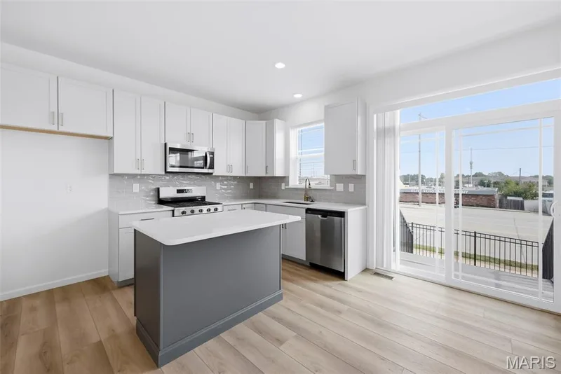 Sliding Glass Door with Transom Window Opens to Steps Leading to Patio — 32 Wingtip Court, St Peters, MO 63376