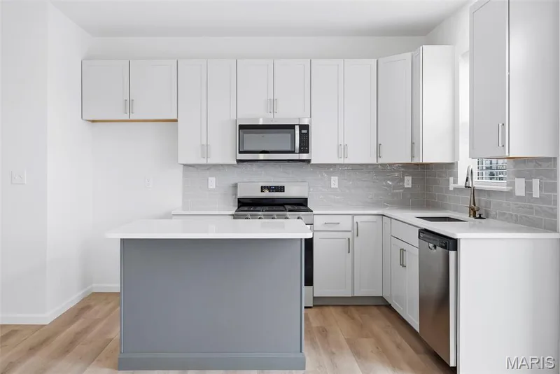 Kitchen Island with Seating Bar and Quartz Countertops — 32 Wingtip Court, St Peters, MO 63376