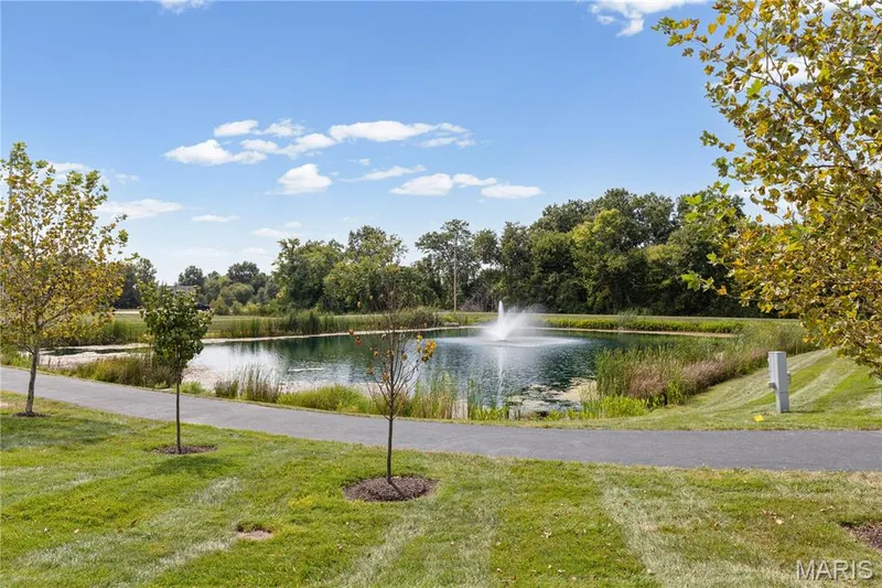 Get that walk in! Everyday! on the walking trail and bask in the beauty of  the Landscaped grounds featuring a pond with a central fountain and mature greenery. — 89 Alta Mira Court, Dardenne Prairie, MO 63368