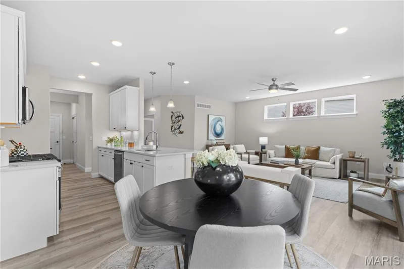 Open-concept living area featuring wood-finish flooring, recessed lighting, a kitchen island with sink, white shaker cabinetry, and a ceiling fan — 89 Alta Mira Court, Dardenne Prairie, MO 63368