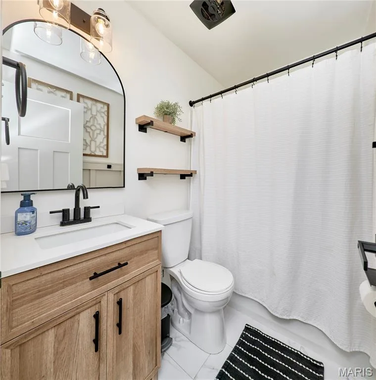 Wood-finish vanity with a white countertop and undermount sink — 415 Westridge Drive, O'Fallon, MO 63366