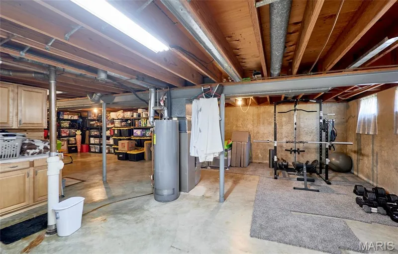 Finished basement with concrete flooring and exposed ceiling joists — 415 Westridge Drive, O'Fallon, MO 63366