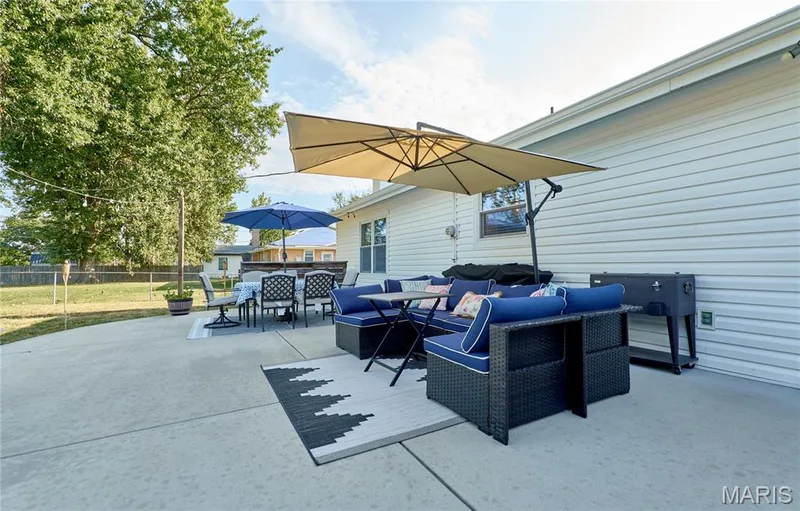 Expansive concrete patio with a single-story exterior featuring horizontal siding and a window — 415 Westridge Drive, O'Fallon, MO 63366