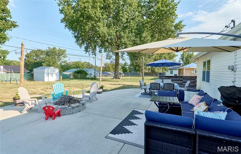 Expansive concrete patio with a built-in stone fire pit — 415 Westridge Drive, O'Fallon, MO 63366