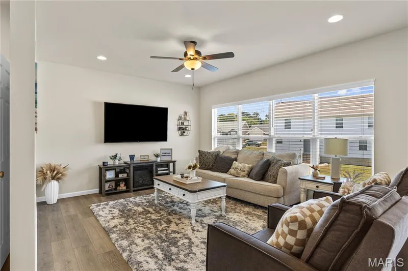 Spacious living area featuring wood-laminate flooring, recessed lighting, and a ceiling fan — 211 Brookview Way Court, O'Fallon, MO 63366
