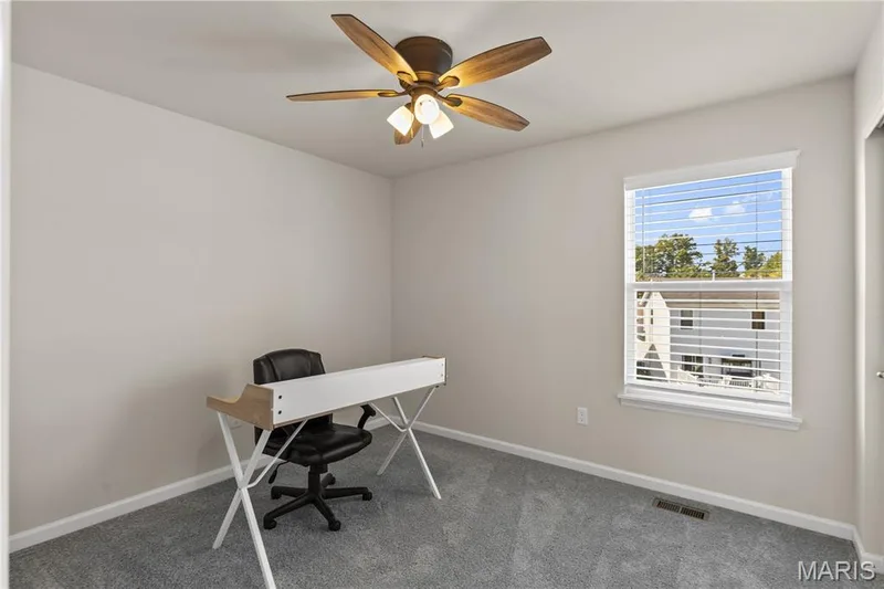 Neutral wall paint, ceiling fan with integrated lighting, window with blinds, and gray carpeting — 211 Brookview Way Court, O'Fallon, MO 63366