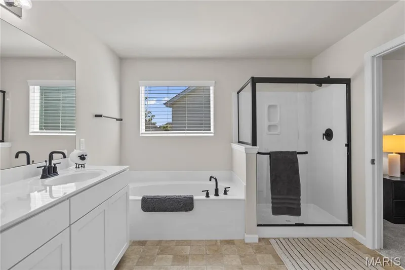 Dual vanity with white cabinetry, rectangular undermount sinks, and matte black fixtures — 211 Brookview Way Court, O'Fallon, MO 63366