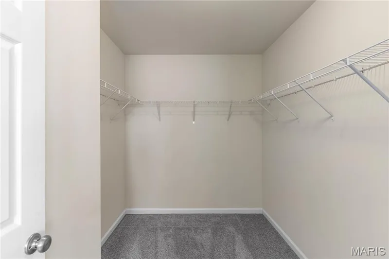 Large walk-in closet with wraparound wire shelving, light-toned walls, and grey carpet flooring — 211 Brookview Way Court, O'Fallon, MO 63366