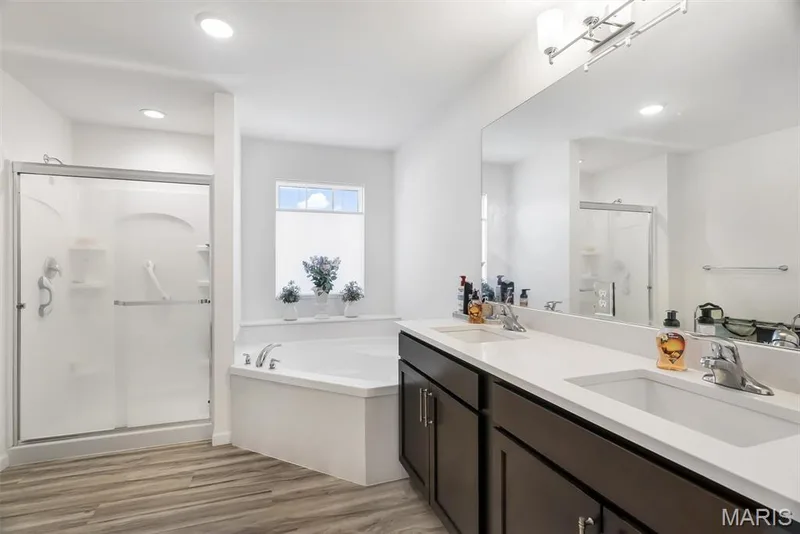 Dual vanity with white countertops, integrated sinks, and dark wood-finish cabinetry — 337 White Orchid Court, Wentzville, MO 63385