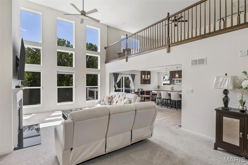 Two-story living area with a fireplace and tall windows — 337 White Orchid Court, Wentzville, MO 63385