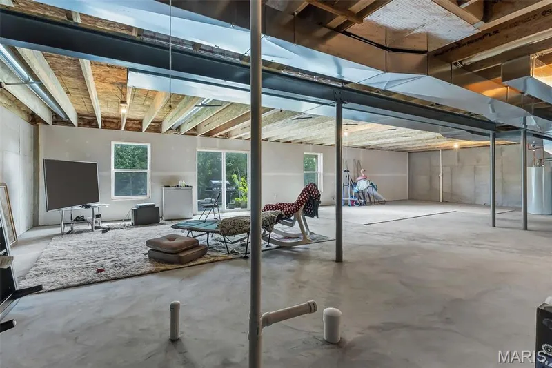 Expansive unfinished basement featuring a concrete floor, exposed ceiling joists, and structural I-beams — 337 White Orchid Court, Wentzville, MO 63385