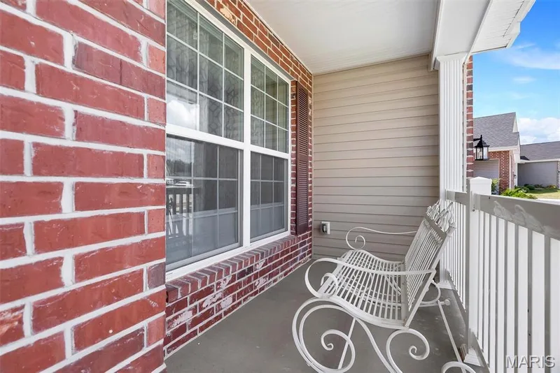 Covered front porch featuring brick siding, horizontal siding, and white window trim — 337 White Orchid Court, Wentzville, MO 63385