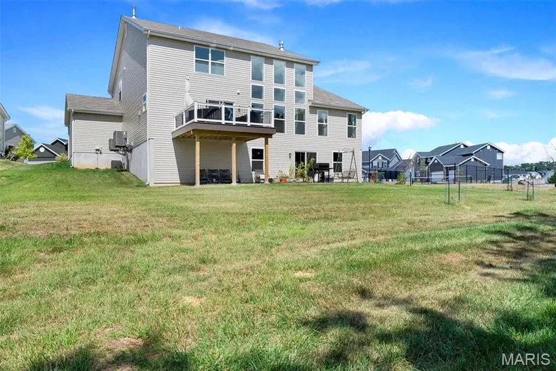 Expansive grassy yard with a multi-level deck and ground-level patio — 337 White Orchid Court, Wentzville, MO 63385