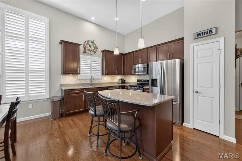Open kitchen with gas range, solid surface counters and island — 1052 Silo Bend Drive, Wentzville, MO 63385