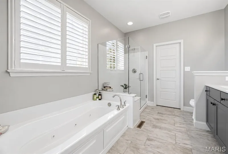 A spa like primary bath featuring a soaking tub, creating a serene retreat for unwinding at the end of the day! — 140 Oakleigh Park Lane, St Charles, MO 63303