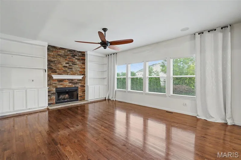 Spacious great room boasts tons of natural light, built-in's and stacked stone wood burning fireplace. — 152 Carlton Point Drive, Wentzville, MO 63385