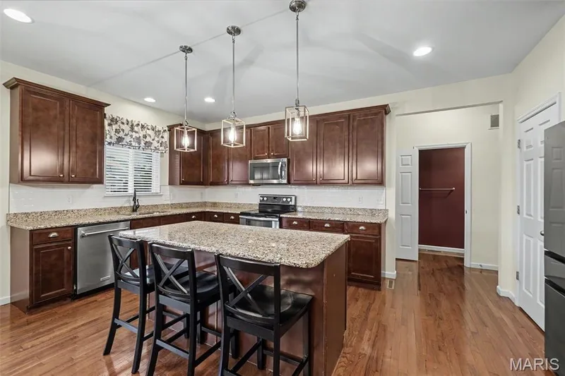 The kitchen features a center island, granite countertops, and pantry. — 152 Carlton Point Drive, Wentzville, MO 63385