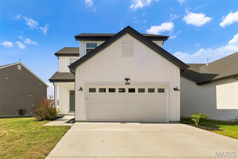 Modern farmhouse-style exterior featuring board and batten siding, a two-car garage with transom windows, and a covered entry — 191 Crestfield Court, St Charles, MO 63301