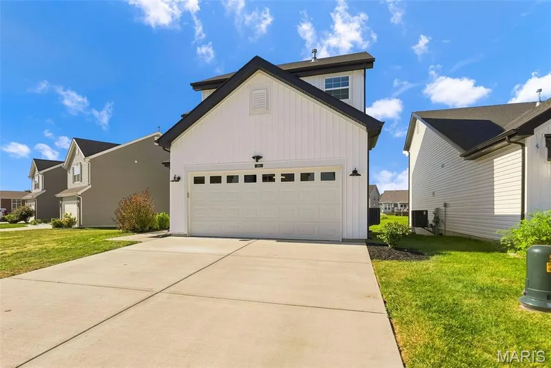 White vertical siding exterior with a black roof and a two-car garage — 191 Crestfield Court, St Charles, MO 63301