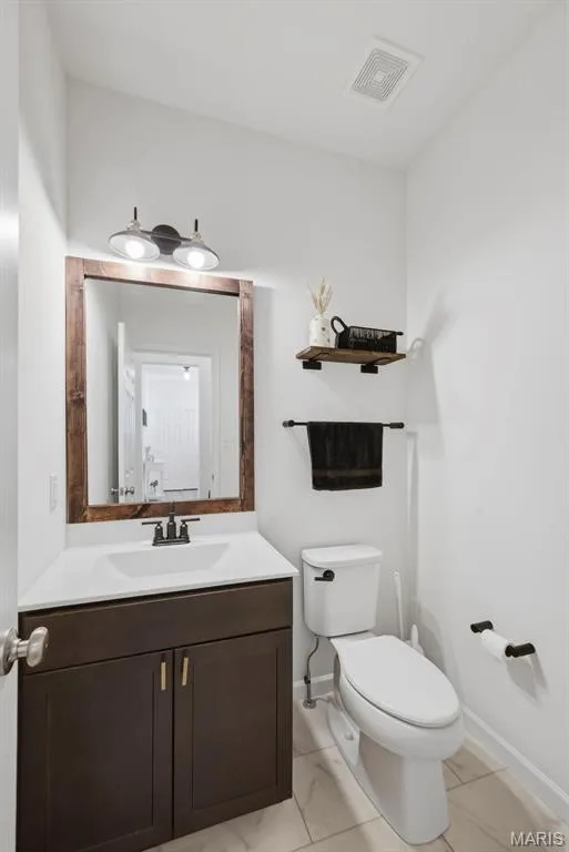 Modern vanity with dark wood-finish cabinetry and white countertop — 191 Crestfield Court, St Charles, MO 63301