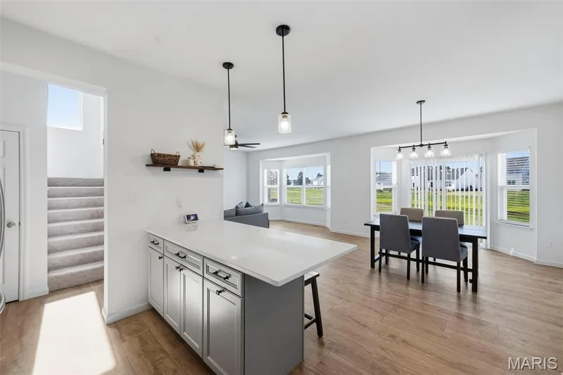 Open concept living space featuring wood-finish flooring, recessed lighting, and large windows — 191 Crestfield Court, St Charles, MO 63301