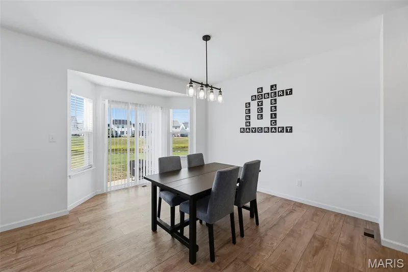 Recessed bay window, glass sliding door, wood-finish flooring, and a modern chandelier — 191 Crestfield Court, St Charles, MO 63301