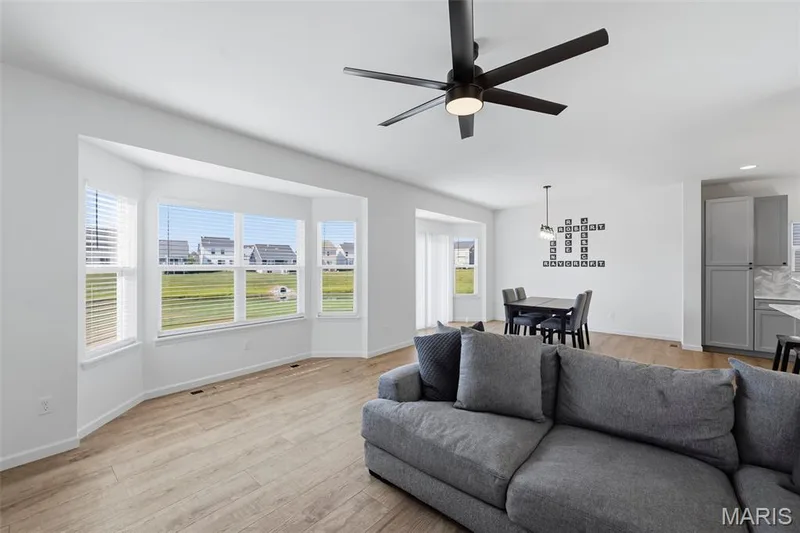 Expansive bay window, wood-finish flooring, recessed lighting, ceiling fan, and open-concept dining area — 191 Crestfield Court, St Charles, MO 63301