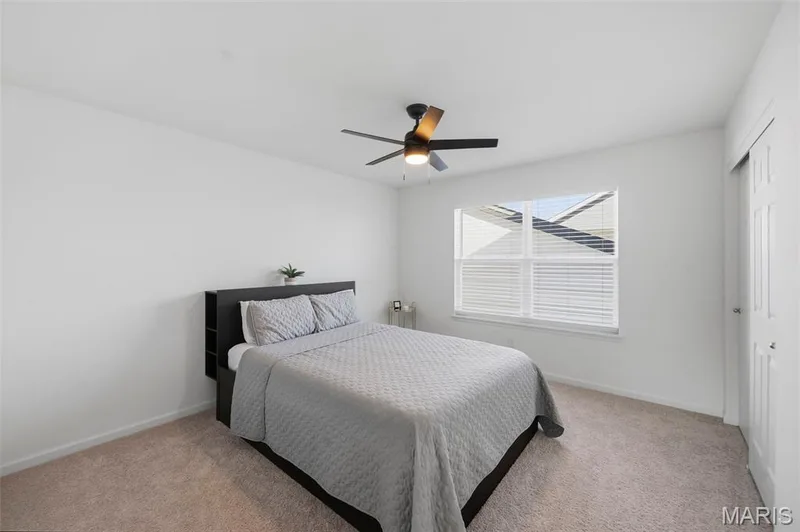 Carpeted flooring, window with blinds, ceiling fan with integrated lighting, and sliding closet door — 191 Crestfield Court, St Charles, MO 63301