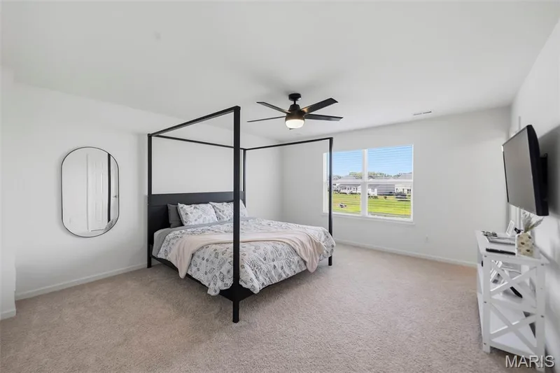 Bright interior featuring neutral carpeting, a ceiling fan, and large windows — 191 Crestfield Court, St Charles, MO 63301