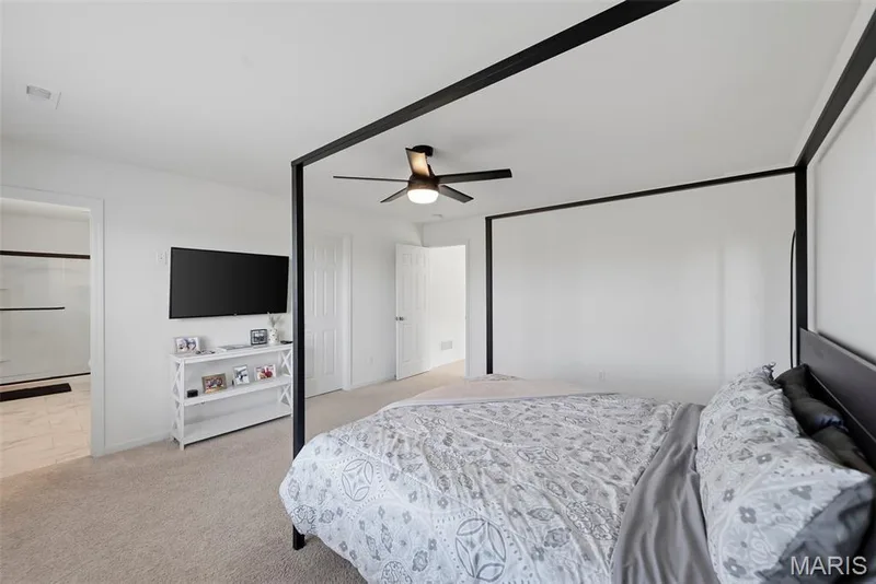 Plush carpeting, ceiling fan with integrated lighting, and a wide entryway leading to an additional space — 191 Crestfield Court, St Charles, MO 63301