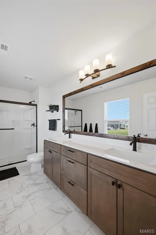 Dual vanity with integrated sinks, wood-finish cabinetry, and matte black fixtures — 191 Crestfield Court, St Charles, MO 63301