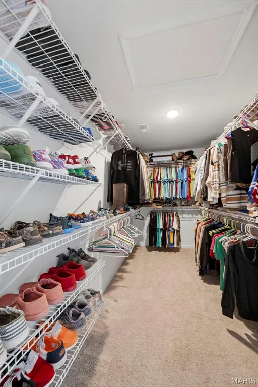 Walk-in closet featuring built-in wire shelving, hanging rods, recessed ceiling lighting, and carpet flooring — 191 Crestfield Court, St Charles, MO 63301