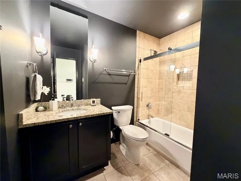 Vanity with granite countertop, integrated sink, and dark wood cabinetry — 584 Sunbridge Drive, Chesterfield, MO 63017