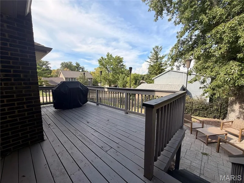 Spacious outdoor deck with railings and a lower-level patio — 584 Sunbridge Drive, Chesterfield, MO 63017