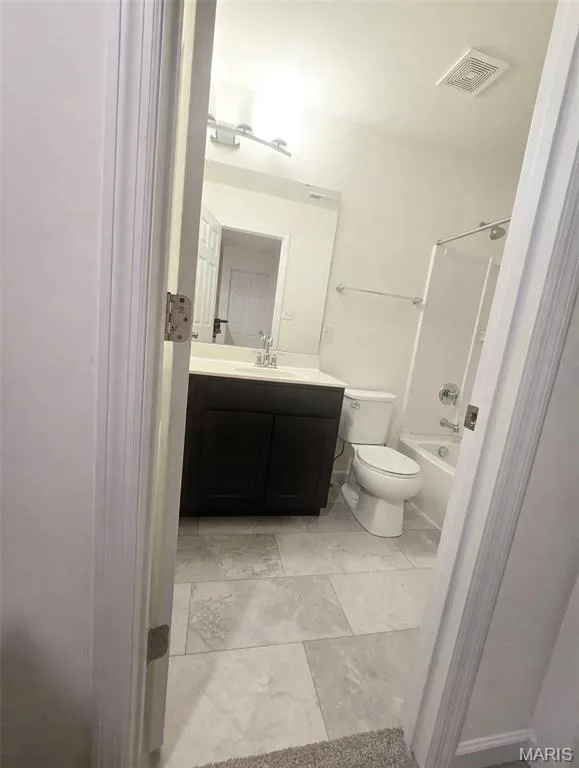 Bathroom featuring a dark wood-finish vanity, white countertop, tile flooring, and a shower-over-tub combination — 157 Day Lily Lane, Wentzville, MO 63385